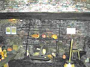 The kitchen of the old hall with its wide fireplace and timber roof.