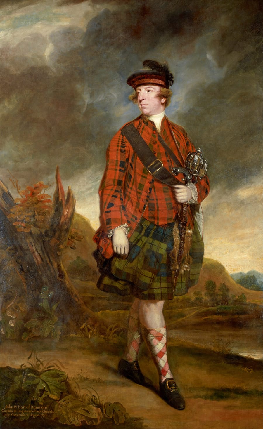 A full-length portrait of a man in Highland dress, tartan plaid and red coat, standing before a mountain landscape.